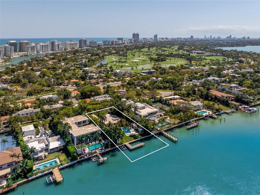 Step into this breathtaking waterfront sanctuary on prestigious North Bay Road. This 4-bedroom, 4.5-bath mid-century estate sits on an oversized 27,013 SF lot w/ 113’ of pristine bay frontage. A grand koi pond entrance leads to sunlit interiors, featuring L-shaped living room, bar, private office, media room, & formal dining area. The fully renovated Bulthaup kitchen combines style & function w/ high-end appliances & a second prep kitchen. The primary suite mesmerizes w/ sweeping water views, dual walk-in closets & a luxurious spa bath. Outdoors complete w/ lush landscaping designed by Raymond Jungles, heated pool, dining & seating pavilions, private dock & a Kalamazoo built-in summer kitchen w/ pizza oven. This home blends privacy & serenity, moments from Miami Beach’s vibrant lifestyle.