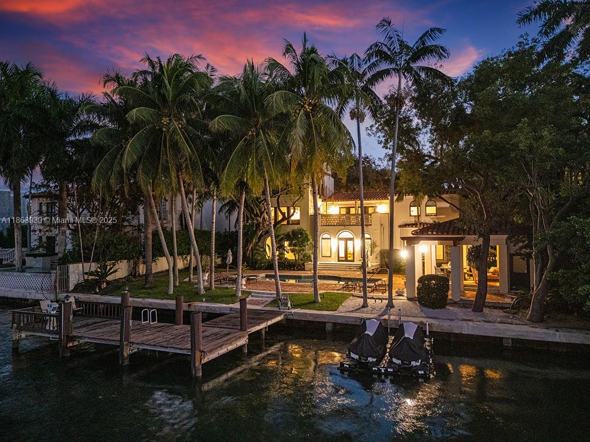 Embrace waterfront luxury living on gated Sunset Island II. This waterfront residence offers 100 feet of prime frontage and timeless architectural elegance. Inside, refined spaces include a private library/office, family and game room, and a fireplace-adorned living room. the primary suite is a true retreat, complete with a spa-inspired bath, wet lounge, private terrace, and a separate sitting area. Renovations by Bart Reines elevate the home with new bathrooms, impact glass doors and windows, and a chef’s kitchen. Resort-style amenities feature a rooftop viewing tower, heated pool and spa, two-car garage, waterfront gazebo, and private dock. A rare offering for those seeking luxury, privacy, and the ultimate Miami Beach lifestyle.