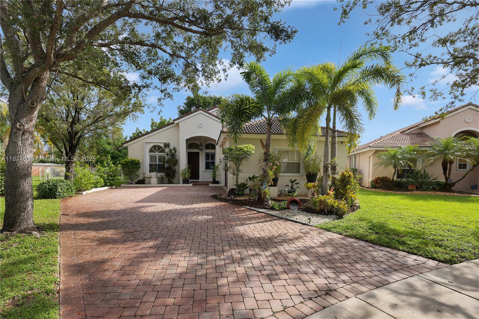 Welcome home to your tropical oasis. This well-cared-for residence offers a bright open floor plan with plenty of natural light. The kitchen includes granite countertops, tile backsplash, stainless steel appliances, wood cabinetry, and a snack bar—ideal for living and entertaining. Porcelain floors flow throughout into a spacious master suite with sitting area. Both bathrooms are renovated with floor-to-ceiling tile, modern vanities, and elegant showers; the master bath has dual sinks, soaking tub, and a make-up area. Enjoy a large fenced yard with peaceful lake views and matured fruit trees, including avocados and mangos. Extras include indoor laundry, long driveway for six cars, newer A/C and water heater, accordion shutters in a resort-style gated community.