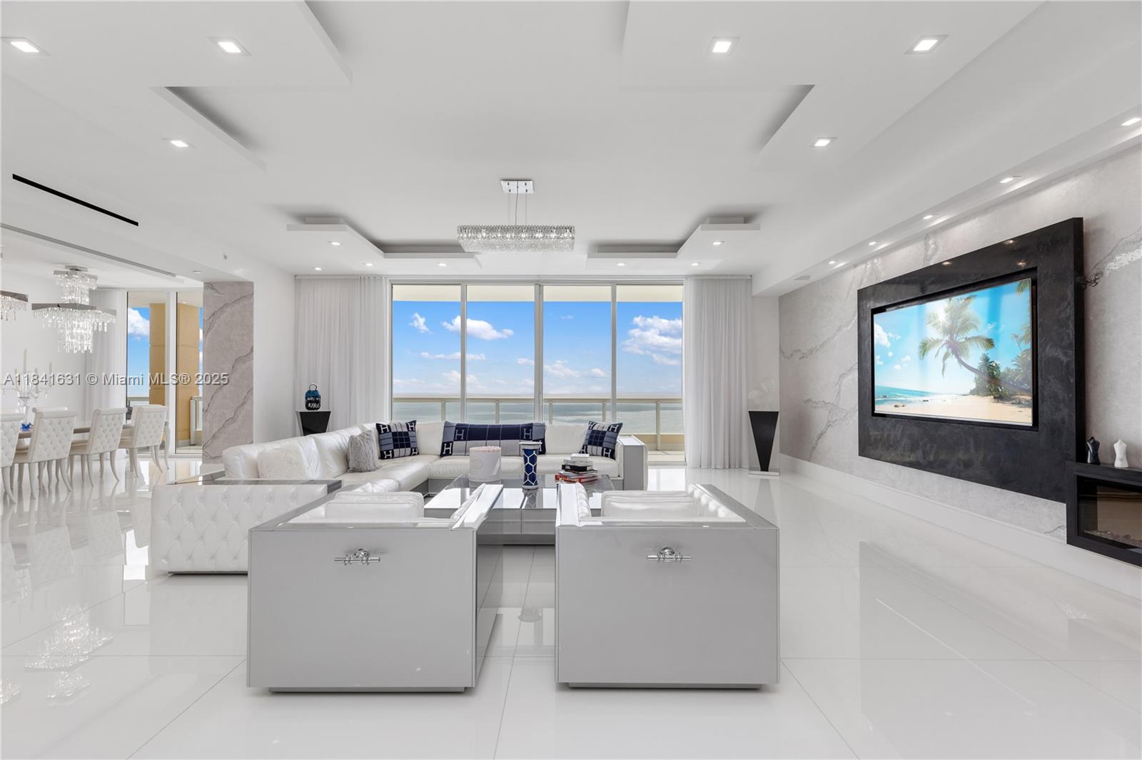 This breathtaking penthouse combines modern design and timeless comfort. Fully renovated and move-in ready, it features floor-to-ceiling windows, luxurious finishes, and a large private balcony perfect for enjoying the stunning ocean and city views. A separate guest room with privacy offers flexible space for family, guests, or staff.
Elegant enclosed balcony featuring a summer kitchen with BBQ, wall-mounted TV, and spacious dining area for indoor-outdoor living.
Enjoy Acqualina’s Five-Star resort lifestyle: 3 oceanfront pools, staffed beach club, world-class spa & fitness, and oceanfront dining incl. Il Mulino, Avra, Ke-uH & Costa Grill—plus children’s program, salon, valet & concierge.
