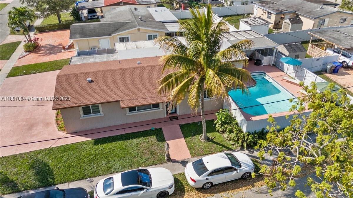 Renovated 4-bed, 3-bath corner home with over 1,600 sqft of living space, including a private in-law suite with separate entrance and bath. Features tiled floors, a sparkling repainted pool, outdoor kitchen, netted covered patio, and dual parking options — a large covered area for 3–4 vehicles or boats, plus a driveway that fits an additional 3–4 cars. Spacious backyard perfect for entertaining. Ideally located near Publix, shopping plazas, and major routes: I-95, Turnpike, and 441.