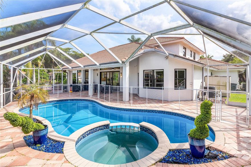 Redefined luxury  waterfront residence. Perfectly positioned on a quiet cul-de-sac, it boasts 180 feet of serene water frontage and breathtaking panoramic views.
Dramatic, open-concept, features soaring ceilings, striking glass staircase, updated marble floors. The gourmet chef's kitchen is a dream, seamlessly flowing into expansive living and dining spaces—ideal for effortless entertaining.
Unwind in the lavish first-floor primary suite. The versatile loft can easily be a 5th bedroom, while the impressive media/rec room offers endless possibilities for fun and relaxation.
Outdoors, enjoy both screened and open patios, a sparkling heated salt pool and spa, and lush, meticulously landscaped grounds. Full impact windows and a whole-house generator ensure complete security and comfort.