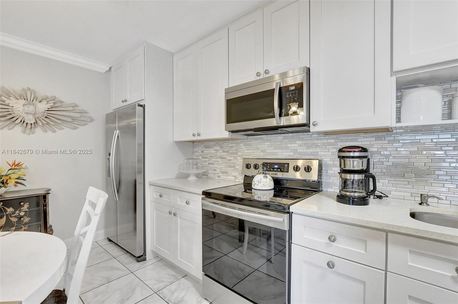 Beautifully furnished 2-bed, 2-bath condo on the 2nd floor, just 10 minutes from the beach. A community for all ages with a low HOA fee, and the kitchen was recently remodeled. It includes wood cabinets with a pull-out trash bin, a stunning backsplash, ample cabinet space, and new stainless steel appliances, as well as a washer and dryer. The unit is very spacious, without popcorn ceilings throughout the entire apartment. All rooms feature crown molding. The balcony, screened for comfort, offers a lovely view of the pool just across the street. Additional features include hurricane shutters, a pet-friendly community situated in a safe neighborhood, conveniently close to I-95, the beach, the Pier, Quiet Waters Park, shopping, dining, and various outdoor activities.