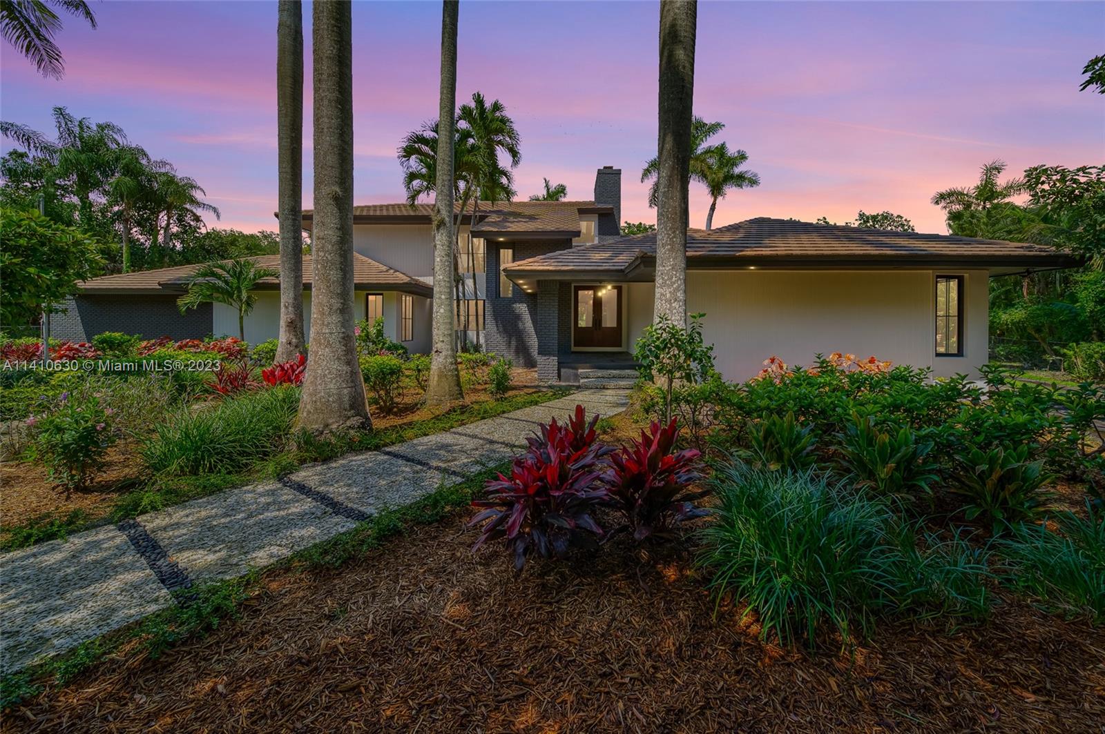 Remarkable North Pinecrest estate home is situated on a gated deep acre lot on a no-through street, perfect for those seeking the utmost privacy. This unique residence showcases a completely renovated modern farmhouse design. As you enter, a grand foyer greets you with soaring ceilings and abundant natural light that illuminates throughout. The gourmet chef's kitchen is a culinary masterpiece, the master suite is a serene sanctuary, complete with a spa-like bathroom and a private sitting area with a cozy fireplace.
The outdoor space is an entertainer's paradise, featuring an expansive covered terrace, a sparkling pool, and lush tropical gardens adorned with a variety of exotic fruit trees. Enjoy the convenience of being just minutes away from top-rated schools, fine dining, and parks.