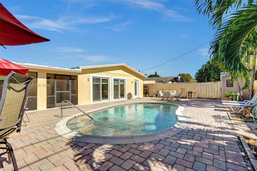 When you enter this showpiece 3 bedroom, 2 bath pool home, your eye will immediately be drawn to a private backyard oasis, which projects through two gleaming glass sliding doors. A thoughtful design seamlessly blends an open living space with a sleek modern kitchen and a split bedroom floorplan. The home features CAT 5 impact windows and doors. Relax in any weather in an enclosed porch. For added comfort there is a finished pantry/utility room. Further features include: on-suite, French doors, Hi-hat lighting, a 10-year-young roof, upgraded electric panel, 3 sheds & sprinkler system. Matching stone pavers in the driveway and kidney shaped pool area are another mark of thoughtful, integrated living that you will love and appreciate for years to come. Near the Hardrock, beaches & major arteries  No HOA. Best offer!