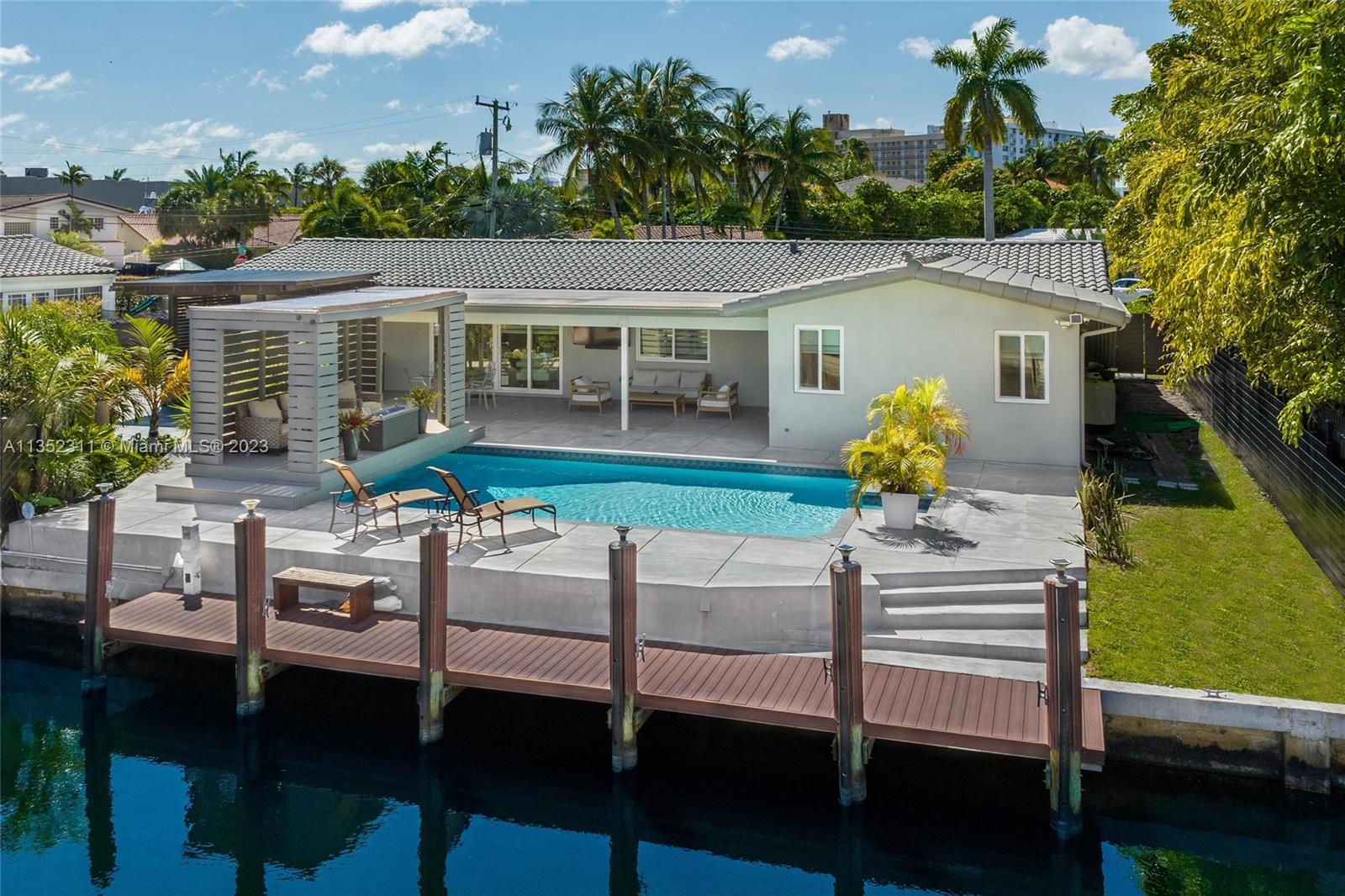 This modern waterfront masterpiece nestled in Eastern Shores is not one to miss! Take in all of the glamorous home upgrades and exquisite designer features including a chefs kitchen with top of the line appliances, Calcutta marble throughout the home, built-in bar, fireplace and more! This high-tech property offers many of the advancements of new age technology, including 16 home cameras and surround sound. Take entertainment outside with poolside lounging area, summer kitchen equipped with bbq, wine & mini fridge, and endless water views. With 58 feet on the water and your own private dock, this home calls for all boating lovers! True South Florida style living is found here! Seller financing available.
