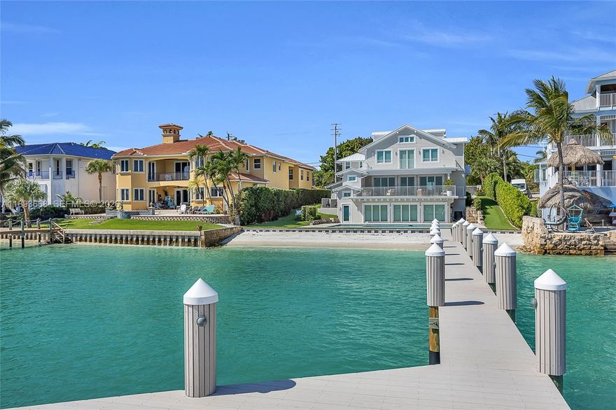Welcome to your breathtaking Intracoastal Blue Water Estate built in 2021 with direct ocean access and no fixed bridges. Nestled along the shimmering blue waters of the Intracoastal Waterway, this beautiful fully furnished home features a rare sandy-bottom private beach which is ideal for swimming, paddleboarding, or simply lounging as boats drift by, and plenty of room for multiple water crafts. Designed for both entertaining and escape, the property includes, two separate guest retreats, each complete with its own kitchen, living room, bedroom, and full bath — perfect for hosting family or friends in comfort and privacy, plus boasts two spacious main-floor bedrooms, while the expansive primary suite offers a luxurious bedroom, a cozy sitting room with a wet bar
