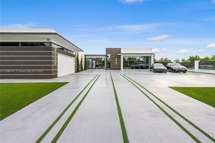 Discover modern luxury in this expansive contemporary home situated on a vast lot. The open-concept design seamlessly integrates the living, kitchen, and formal spaces, creating a spacious and inviting atmosphere. The chef's kitchen, ideal for entertaining, is accompanied by a secondary outdoor kitchen near the pool. Large-scale windows from floor to ceiling flood the interiors with natural light, showcasing the sleek and stylish architecture. Step outside to a resort-style heated pool, offering a perfect blend of relaxation and entertainment against the backdrop of the generous outdoor space. This home is a masterpiece of contemporary living, where design and comfort harmonize to create an unparalleled lifestyle experience. Offered fully furnished for a seamless transition.