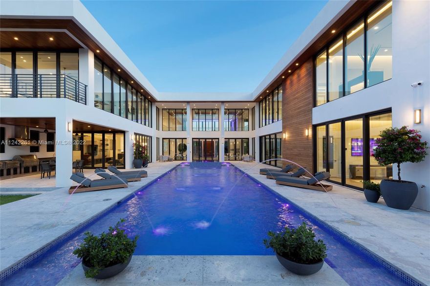 A North Pinecrest modern masterpiece that effortlessly blends elegance and nature. Through walls of glass, take in 360 views of tranquil water elements, sunlight, and foliage. Newly completed, this estate features smart home technology, high end finishes, home theater, elevator, large den, two driveways & thoughtful extras. The 1,300 SF primary suite will exceed expectations with wraparound windows, sitting area, spa-like bathroom & walk-in closet with laundry. Experience seamless indoor/outdoor living with folding glass doors opening to your 75’ tiled pool and jacuzzi, summer kitchen with electric screens, and cabana with dramatic marble slabs & full bath. Wood and lighting accents flow from outside to in, adding warmth to the sleek design. This Pinecrest home is in a class all its own!