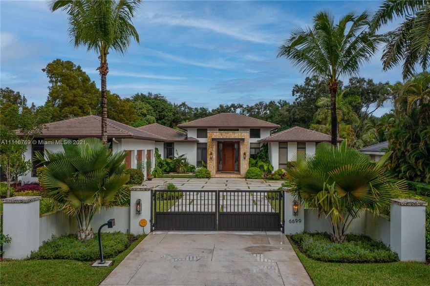 This one story Contemporary Tropical Luxury estate in North Pinecrest is fully gated and gives you the opportunity to experience the ultimate living. Elegant water feature welcomes you at the entrance to this property. Open floor plan w/oversize porcelain tile throughout with 14 and 18ft ceiling heights. Gourmet kitchen, custom wood cabinet w/top of the line Thermador appliances and white quartz counter top, huge hidden walk in pantry, wet bar next to the family room and a the cabana bath. A stunning glass wine gallery takes this property to the luxury next level. An inviting outdoor oasis awaits w/an expansive yd w/tranquil reflective pool, jacuzzi, tanning ledger & covered summer kitchen. Impact windows and doors, 3 car garage with e entrances. Prime Pinecrest School nearby 1 block away.