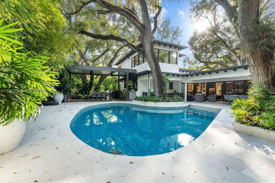 Experience a modern South Coconut Grove residence that perfectly blends luxury design, privacy, and lifestyle. Nestled in an exclusive residential enclave, this turnkey home sits on an oversized 13,000-sq-ft gated corner lot nearly double the average lot in the Grove offering exceptional space and tranquility amid lush tropical surroundings. Immaculately renovated by Farache Bromberg Design Studio & Casa DDI, the 5-bed, 4.5-bath residence features a spacious open floor plan with wood and porcelain floors, abundant natural light, and custom architectural details. The chef’s kitchen includes Miele appliances and a waterfall island, connecting to a formal dining room, living area with exposed beams, and intimate sitting room. The double-height primary suite evokes a resort ambiance, complemented by spa-inspired baths and a green roof terrace. Outdoors, enjoy a diving pool, covered terrace, and lushly landscaped grounds with mature oaks. Major upgrades include new metal roof, electrical, plumbing, HVAC, and irrigation. Minutes to the village center, marinas, and top-rated private schools—this home captures modern comfort, timeless design, and Miami luxury living.