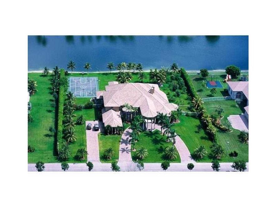 Custom Mediterranean estate w/stone columns,gorgeous marble slabs & chef's kitchen nestled in gated community on a 2 acre water front lot.8 bdms,gym,playroom & grand great room.Massive marble master ste. with impressive his/her showers & large whirlpool t ub.Each bathroom features marble with Jacuzzi tubs.Backyard w/ lighted basketball/tennis court, covered patios & summer kitchen.Whole-house generator & hurricane impact glass.