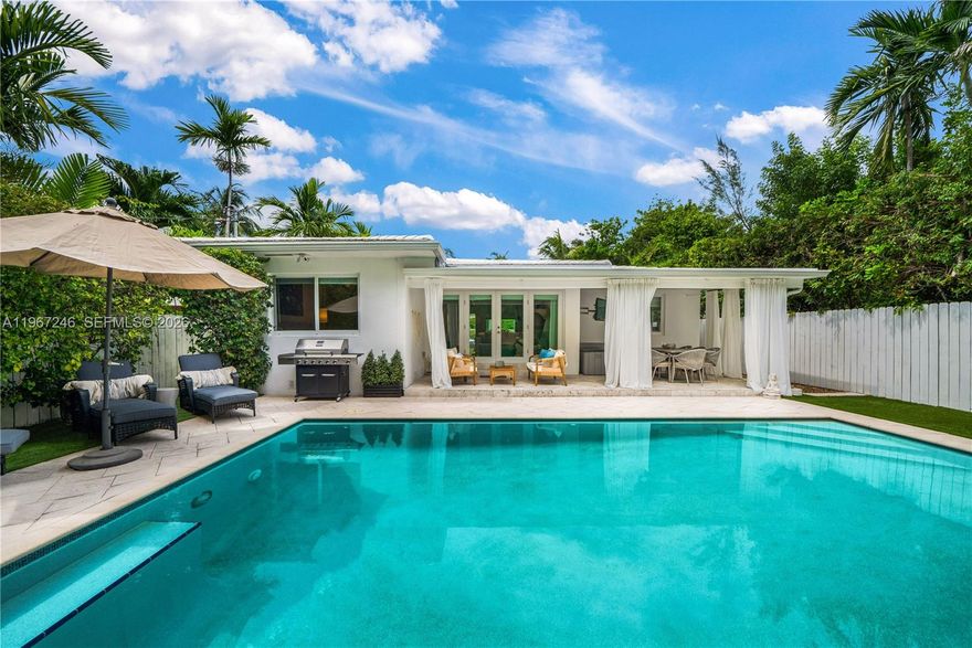 Discover refined living in Miami Beach's tranquil Lakeview neighborhood. This thoughtfully designed 3-bedroom home. The tastefully furnished interior includes a versatile laundry room that easily converts into a guest room with a convenient half bathroom. Cook and entertain in style with the well-appointed kitchen, complete with top-of-the-line appliances and a subtle wine cellar touch.Enjoy the open living and dining, along with a patio overseeing a heated pool and lush greenery, all guarded by a security system. Park up to 3 cars in the circular driveway.