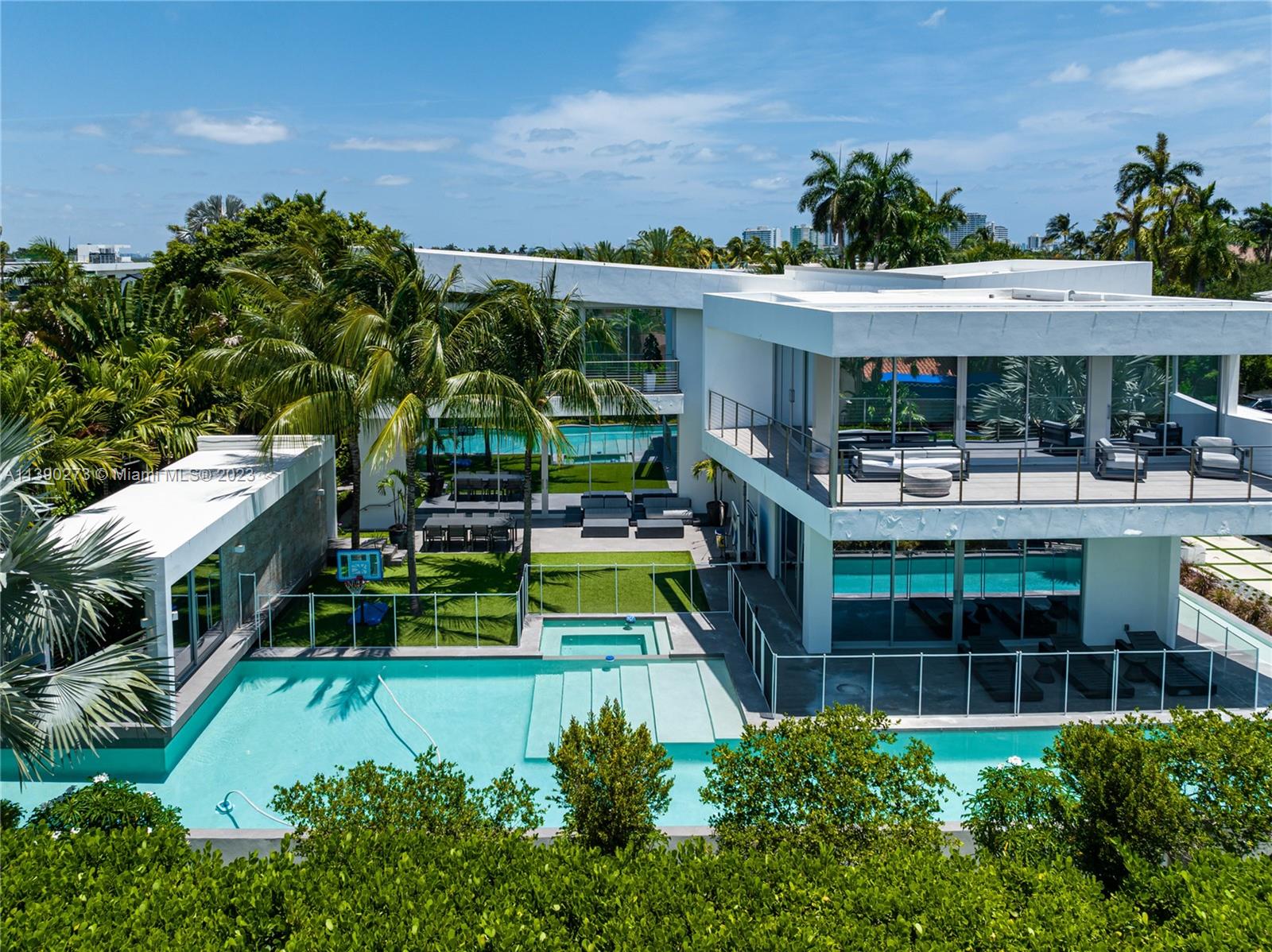 Exquisite modern residence on an extra large corner lot on Miami Beach's guard gated Hibiscus Island. Showcasing impeccable design & meticulous attention to detail, the open floor plan features soaring ceilings & panoramic doors to the exterior. Gourmet kitchen features Thermador + Wolf appliances & custom cabinetry. The primary suite is a serene oasis, featuring a spa-like ensuite bathroom & 2 spacious walk-in closets. Additional ensuite bedrooms provide comfort & privacy. The outdoor living area is perfect for relaxation & entertainment, with a sparkling pool and plenty of space for lounging or dining al fresco. Private guest house. Hibiscus Island offers a waterfront park, tennis & basketball courts, playgrounds & 24-hr police officer at the main entrance.