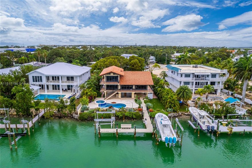 OVER 2,600 Sq. Feet of air-conditioned living area, AND A TOTAL OF OVER 5,000 SQUARE FEET of structure including patios & porches. Relax in the comfort of the unyielding strength and security of concrete construction, concrete tile roof, impact glass windows & sliders. Located on an elevated 12,700 Sq Ft lot with privacy and security, you will enter the property through the walled and auto gated entry, with an expansive paver driveway. There are 2 understory carports, and a cargo lift to the elevated floors. Parking for multiple vehicles. The upstairs offers 2 generous master suites with en-suite bathrooms. The sub floors are poured concrete and solid!!!! There is also a concrete safe room.