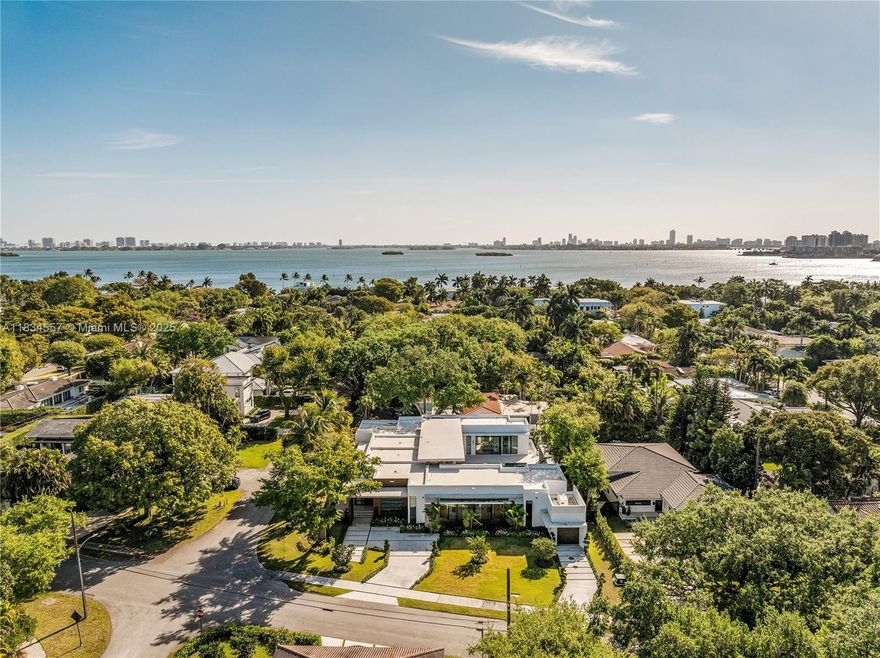 Modern luxury meets coastal elegance at 1200 NE 94th St - an exquisite single-story estate just steps from Biscayne Bay. Set on a 17,880 sq. ft. lot, this 4,600+ sq. ft. under air. This residence features soaring 12-ft ceilings, imported Italian wood floors, and a chef's kitchen with Thermador appliances, Hibachi grill, wine bar, and pass-through to the outdoor kitchen. Every room opens to a resort-style saltwater pool. Enjoy full en-suite bedrooms, Leutron lighting, whole-home water filtration, EV chargers, a 33kW generator, and smart security. A rare opportunity to own a turnkey entertainer's dream in one of Miami's most desirable neighborhoods.