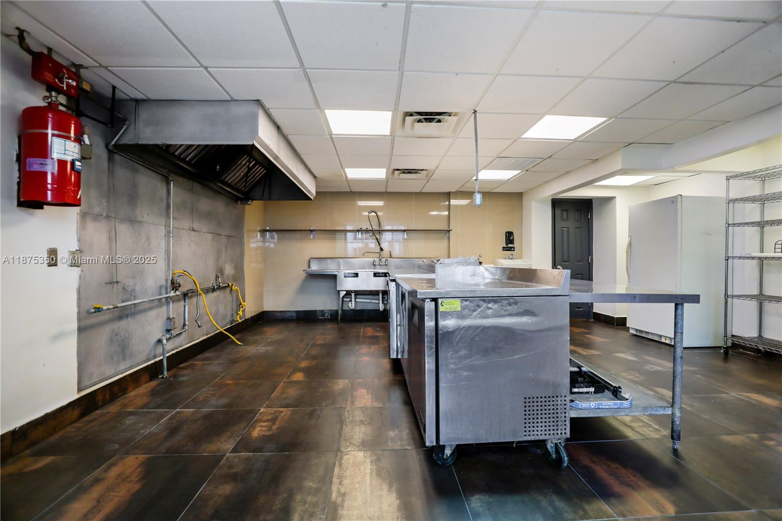 Prime corner retail unit with two floors and a complete kitchen buildout. The first floor includes a commercial hood system, dishwashing station, multiple refrigerators, hookups for grills, fryers, ovens, and more, plus a half bathroom. The second floor offers flexible space for storage or office use and features a walk-in refrigerator. The unit is fully air-conditioned for comfort and efficiency. It is also equipped with a grease trap and holds a valid kitchen license. Conveniently located near Tamiami Airport and with easy access to 826 N, this high-visibility property is an excellent opportunity for an owner-operator or investor seeking a turnkey space.
