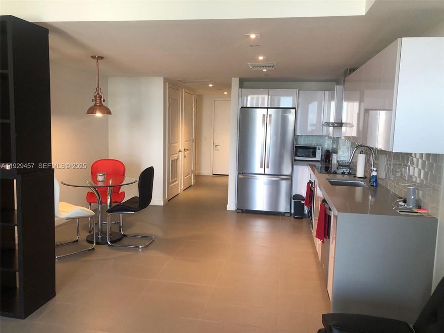 Spacious partially furnished studio featuring high ceilings, an expansive terrace with high-impact sliding panoramic windows, stainless steel appliances, a washer & dryer, a microwave oven, and included basic cable, internet, and water. The unit comes with a Murphy bed, a round glass table with three chairs, and an open rack divider separating the kitchen and living area. Enjoy over 3,000 sqft of resort-style amenities, including three swimming pools (rooftop and two on the 9th floor), indoor and outdoor jacuzzi, sun deck, state-of-the-art gym with water view, spa, sauna, two massage rooms, yoga garden, racquetball and volleyball courts, social room, children’s playground, and business center. The building offers 24-hour valet, security, and concierge services, and is within walking distance to the Metro Mover, with beautiful views of the Port of Miami and Downtown.