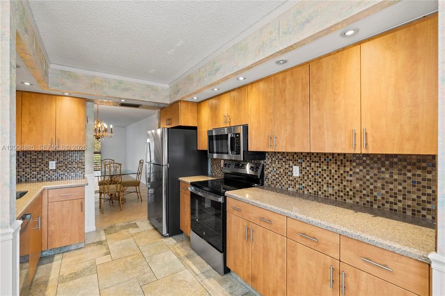 Welcome home to this beautifully maintained and spacious 2-bedroom, 2-bath residence. The open-concept living and dining area flows seamlessly into a large Florida room, offering peaceful garden views—perfect for relaxing or entertaining.

The modern kitchen features new stainless steel appliances and elegant granite countertops, while the in-unit washer and dryer add everyday convenience.

The primary suite includes a generous walk-in closet and a private en-suite bath with a walk-in shower, creating a comfortable retreat.

Ideally located within walking distance to the theater, main pool, fitness center, jacuzzi, and scenic lazy river walking pool, this vibrant community offers exceptional amenities. Residents also enjoy card rooms, ample guest parking, and 24-hour gated security with roving patrols.

Freshly painted with minor bathroom updates, this home is truly move-in ready.