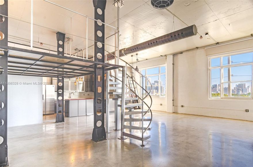 Live/work Modern industrial style open - concept Loft with exposed ductwork, metal beams, and polished concrete floors that give the space an authentic urban edge and mezzanine level. Open floor plan and minimalist aesthetic. kitchen is equaled with stainless steel appliances located in Miami's Creative District 1,063 Sq. Ft.