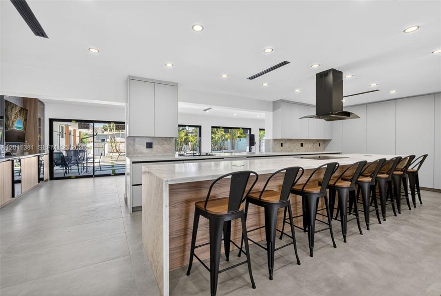 Rarely available oversized 4,000 sq ft residence in the heart of Hollywood Hills, fully renovated and thoughtfully redesigned with a seamless blend of modern design and functional living. This two-story smart home offers a spacious open-concept layout with clean architectural lines and a bright, airy feel throughout. The chef’s kitchen serves as the centerpiece, featuring Italian cabinetry, Taj Mahal quartzite countertops, and fully paneled appliances for a sleek, cohesive look. The home offers seven bedrooms, including three on the ground level and four upstairs, providing flexibility for guests, multi-generational living, or office space. The primary suite is a true retreat, highlighted by a gorgeous bedroom and an expansive custom walk-in closet. Interior highlights include a custom oak staircase, spa-inspired bathrooms, upstairs mini bar, impact windows and doors, upgraded PVC plumbing, and a laundry room with abundant storage. A two-car garage adds convenience and functionality. The outdoor space is designed for both relaxation and entertaining, complete with a heated pool with new equipment, outdoor shower, expansive patio areas, and an outdoor kitchen—creating a true private backyard retreat. Ideally located near multiple houses of worship, as well as shopping, dining, and major roadways. A rare opportunity to own a turnkey home of this size and caliber in a prime Hollywood Hills location. *Select images have been virtually staged to showcase the home’s potential.*