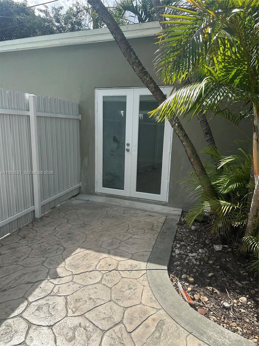 Charming private efficiency with separate gated entrance, front porch, and rear patio. Spacious open studio layout featuring tile floors, mini-split A/C, kitchenette with full refrigerator and microwave, and a full bathroom with tub. Freshly painted and renovated, ready for immediate move-in. Enjoy a quiet and private setting surrounded by tropical landscaping. Utilities included and large private storage room available. Conveniently located near shopping, transportation, and major roadways. Call listing agent