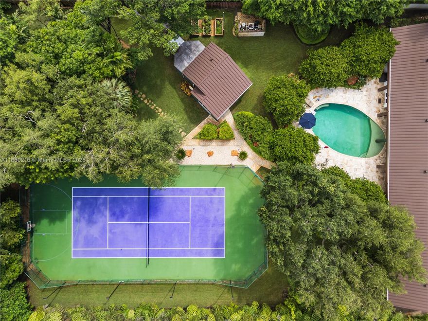 Tucked away amidst lush tropical landscaping, this mid-century modern home is a hidden gem offering unparalleled privacy & serenity. Accessible through a discreet gated entrance, the property spans an expansive 1.25 acres with enchanting greenery that evokes the tranquility of a secluded Tulum-inspired oasis.
Positioned on one of Pinecrest’s most private lots, the main residence features 4 brms, 3.5 bths, & lg  private office.  The modern kitchen, adorned with high-end finishes, is a chef's dream, seamlessly blending style and functionality.
Outdoors, your personal retreat awaits: sparkling pool framed by lush foliage, lighted tennis court & a detached 1/1 guest house. This single-story home is a masterpiece for those who cherish fine craftsmanship & the ultimate in seclusion.