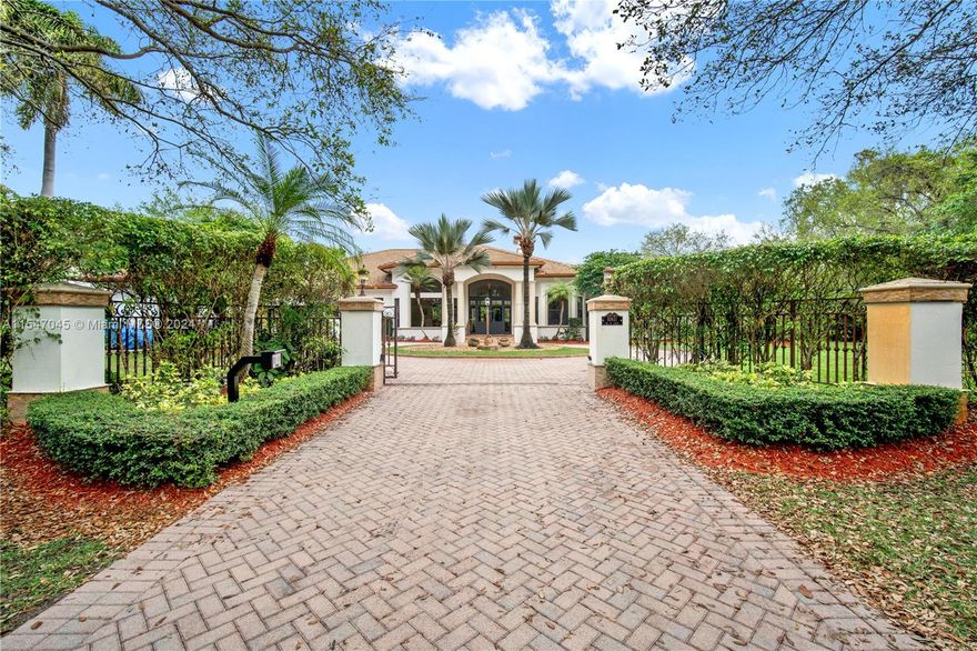 Majestic Pinecrest Estate,  5-bed, 4.5-bath home with den on gated 38,332 sq ft lot. The home boasts 14-ft ceilings adorned with crown moldings. The living room features a fireplace, flowing to the backyard. The kitchen with neutral wood cabinets, granite countertops has a large work prep island. Enjoy gatherings in the family room with a custom entertainment center & bar. The primary suite & den are separated from other bedrooms for privacy. The living areas have travertine polished floors & bedrooms are dark Brazilian wood. Updates include: new roof (2018), impact windows and doors (2023), 3 AC units(2018, 2021, 2022)  2 water heaters (2022), resurfaced pool, new pump, jacuzzi heater & slate deck. Gas connection available and EV charger installed. This Pinecrest gem offers luxury living.