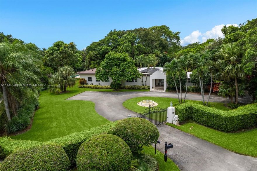 [A Miami Signature Home] What's it all about? Is it the acre property, on idyllic grounds, that offer privacy and tranquility? Could it be the pond, the footbridge or the dreamy lagoon-shaped pool? Is it the gated entry with long winding drive? Perhaps it's the home itself featuring volume ceilings, a split bedroom plan, large closets, newer roof/windows, storage rooms plus solar panels? Maybe it's the floor plan being conducive to extended families, with its 3/3 in main house plus  1/1 with private entry; could it? In fact, it's a combination of all the above AND the reality that it's sweetly priced for your pocketbook! Go ahead; you've earned the zip code - come and get it!