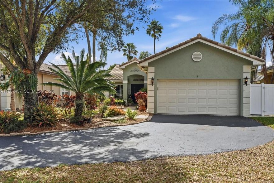 Move-in ready upgraded home on a quiet cul-de-sac in desirable Arboretum in Davie. New hurricane impact windows and doors. Updated kitchen with wood cabinetry, granite countertops, stainless steel appliances, induction stove, wine cooler, and wood-look laminate flooring with new baseboards. Front bath features  frameless glass shower, granite counters, and cherry wood vanity. Primary suite offers walk-in closet, custom wood vanity with granite, Roman tub, and separate stone-floor shower. Updates include new hot water heater, garage refrigerator, full gutters, critter prevention, and roof still under warranty. Private PVC-fenced yard with deck, paver patio, shed, and Govee smart lighting.