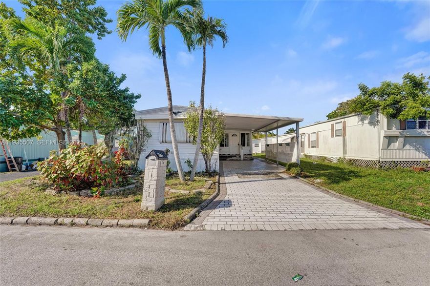 Located in an all-ages community with no HOA approval required, this bright and airy home features a spacious, open layout with 2 bedrooms and 2 bathrooms, complemented by newer vinyl plank flooring throughout. The enclosed porch/patio offers additional living space—ideal for relaxing or entertaining year-round. A separate laundry room provides ample storage, and a large enclosed shed adds even more storage options. The land conveys with the sale. Conveniently situated near expressways, Markham Park, IKEA, Sawgrass Mills Mall, and a wide selection of shopping and dining.