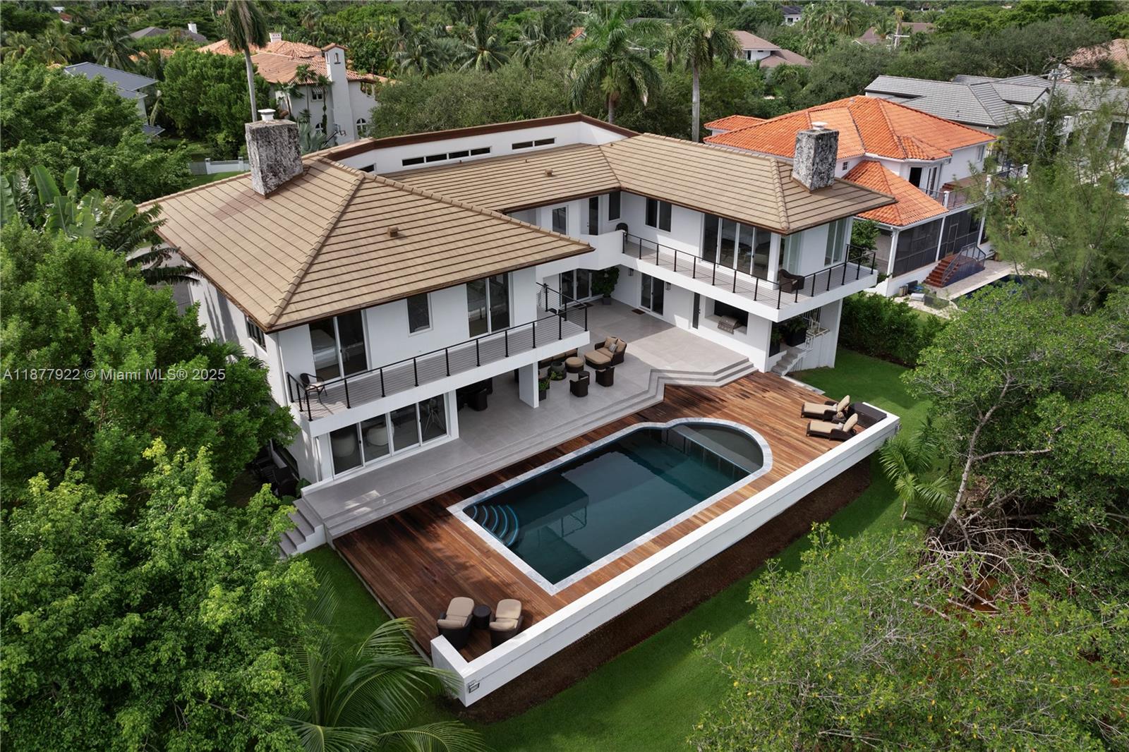 Welcome to Hammock Oaks Harbor—an exclusive, waterfront community of 18 homes, nestled inside the gated
Hammock Oaks neighborhood, & beside the breathtaking Fairchild Tropical Botanic Garden. This fully renovated
home is set on an expansive 17,500+sqft lot & includes a deeded 40-ft dock with 1 high-bridge to bay. The
residence is showcased by soaring 22-ft ceilings & abundant windows that flood the home with natural light. The
1,600sqft primary suite features an ante-room, private den, walk-in closet, wood-burning fireplace, & a wrap-
around porch. Wine enthusiasts will appreciate the 1,200-bottlecellar, while fitness lovers will enjoy the 600+sqft
gym with an attached office/playroom. At under $900/sf, this home is the least expensive home providing open
water access on the market!