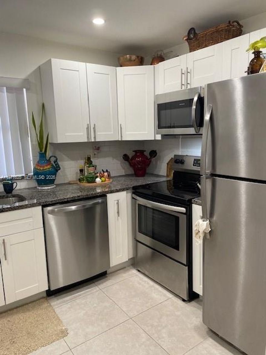 Discover this premier corner unit, a 2/2 residence masterfully reimagined for the sophisticated buyer. This home features a clever split layout with oversized living zones and expansive bedrooms The luminous kitchen shines, a cozy breakfast nook, and elegant stone counters—two bathrooms featuring a custom tub and walk-in shower. The primary retreat offers a garden vista. Relax within the versatile enclosed patio year-round.