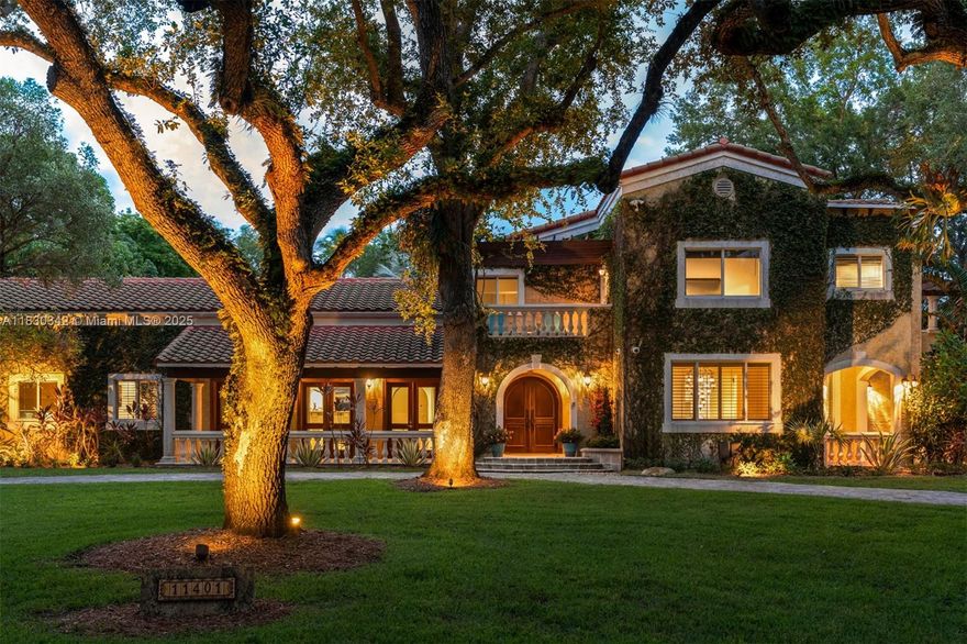 Stunning Mediterranean Revival home with ivy-covered facade on a tree-lined street in Pinecrest. This romantic estate features balconies and porches with balustrades, 6 beds, 5.5 baths including a service room. Renovated with porcelain floors, impact windows, resurfaced pool, and new clay barrel tile roof. The kitchen offers marble counters, wood cabinetry, Wolf/Subzero appliances, and a wine cellar. Breakfast area with bay window overlooks the pool/spa, lush palms, and fire pit. Upstairs primary suite has a dual shower, soaking tub, and walk-in closet. Formal living room with wet bar and wood-burning fireplace.
