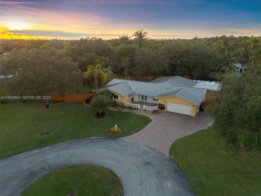 Welcome to 12920 SW 108 Place— a beautifully updated family home tucked into a quiet cul-de-sac in Pine Shores. Sitting on an oversized 24,092 SF lot, this property gives you the space, privacy, and comfort everyone is looking for, with lush landscaping, fruit trees, and multiple terraces that are great for entertaining. The metal roof was done in 2024 and the plumbing has been updated to PVC. Inside, the layout flows naturally with spacious living and family rooms designed for everyday living and effortless entertaining. The kitchen feels like a true chef’s space, featuring high-end appliances, a large working island with a secondary sink, S/S refrigerator and freezer set, and plenty of cabinetry and counter space. Just off the kitchen is a bar-ready nook with wine coolers & open shelving that works perfectly for morning coffee or hosting friends in the evening. The home offers generous bedrooms with custom closets, multiple living and dining areas, and bright interiors filled with natural light. Outside, over 85 feet of covered patio space creates the perfect setting for al fresco dining, weekend gatherings, or simply unwinding. The side-entry driveway easily fits a full-size RV or boat and comes equipped with hookups and secure gated access. Additional features include impact windows, plantation shutters, a two-car garage, and upgraded security systems. With top-rated schools nearby and a true neighborhood feel, this home delivers the lifestyle, convenience, and location.