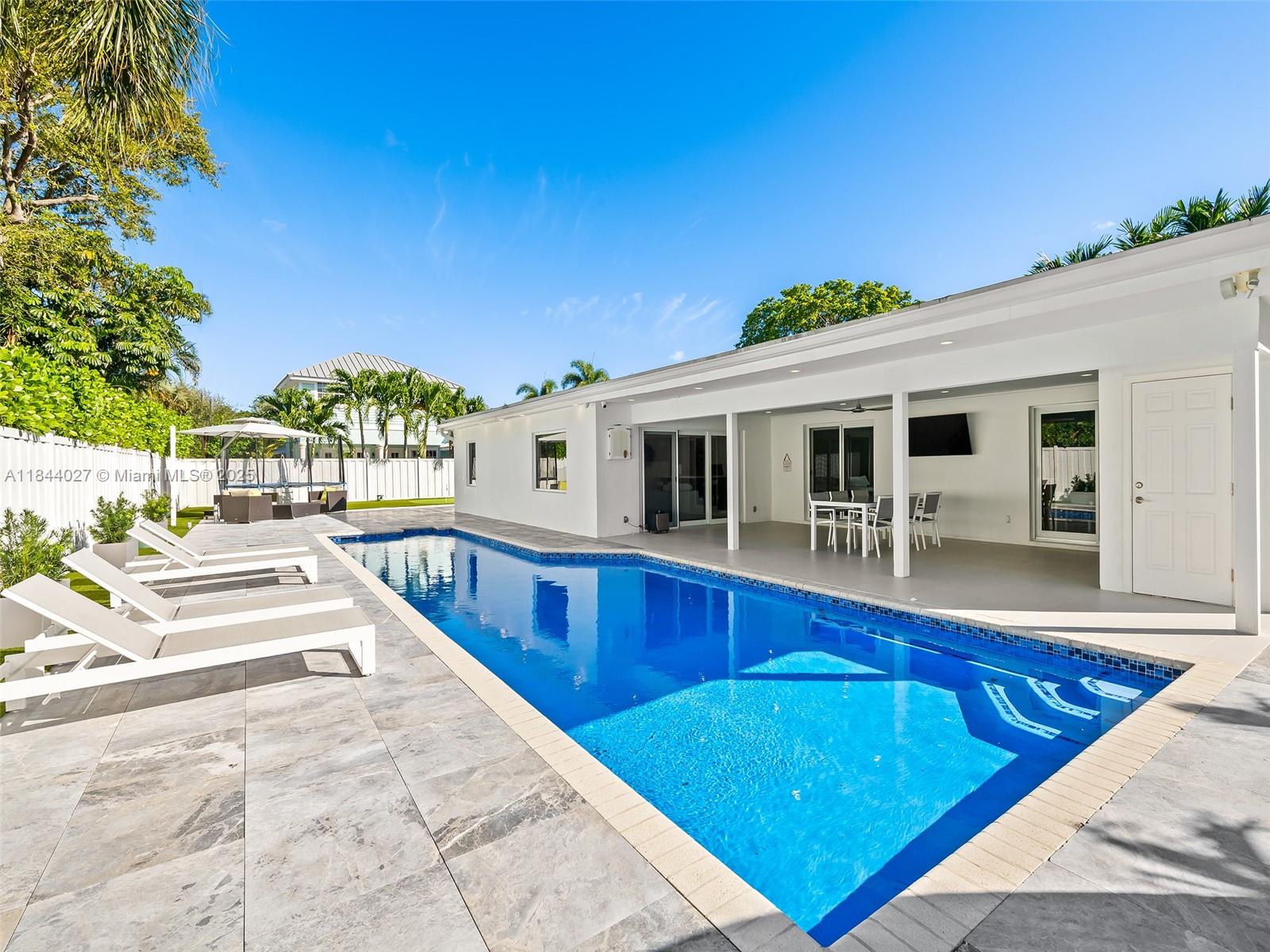 Completely upgraded & renovated to the highest standards in 2021! Located on one of the most sought after addresses, in THE BEST SCHOOL DISTRICT of Ft Lauderdale! Some of the upgrades include; NEW ROOF, new HIGH IMPACT DOORS & WINDOES, NEW AC's, BRAND NEW BATHS & KITCHEN, new PORCELAIN TILES throughout, NEW ELECTRICAL & PLUMBING, NEW APPLIANCES, BLACK-OUT's at each room and many, many more! Desirable split layout floor plan. LARGE COVERED PATIO area providing plenty of rooms to play and store toys. LARGE SIZE LAP POOL with new tiles. CABANA BATH & OUTDOOR SHOWER. Elegant tropical landscaping & FENCED COMPLETELY to provide the utmost privacy. CIRCULAR PAVED DRIVEWAY plus a TWO CAR GARAGE! Fine dining and shopping all within walking distance as well as being only one mile to the beach!