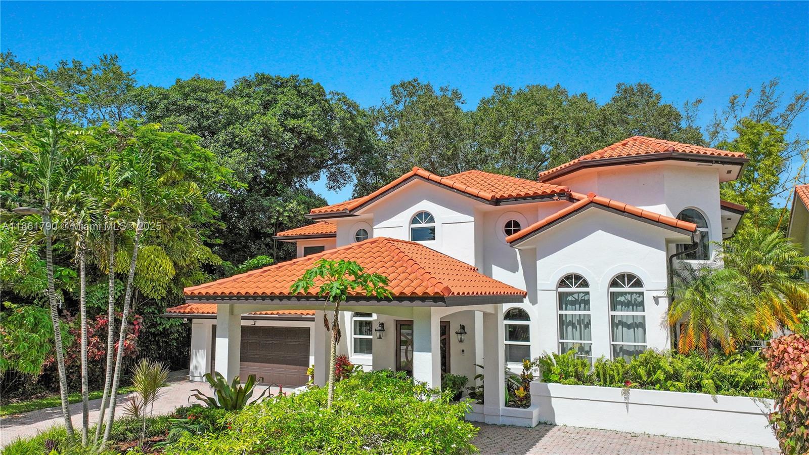 Stunning Mediterranean style villa nestled amidst lush gardens with detailed landscaping, located in the highly coveted and quaint neighborhood of South Miami. This residence is ideal for large families, offering 6 beds. and 6 full baths, split between two levels, with an office on the 2nd floor. It's spacious living-room has double-height ceiling with a wraparound hallway above. It also features a large kitchen that opens to the family room and a breakfast nook overlooking the serene patio. The backyard itself is a whole world of its own with a gazebo that houses a summer kitchen with a dining area, a heated pool with a waterfall, and lots of space to entertain, play, and relax. Add. feat: Impact windows and doors, newish A/C's, mosquito mist system, gutters with leaf filters, and more.