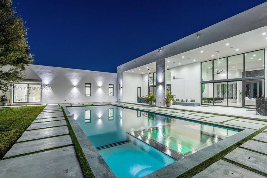 One story modern estate built in 2020 with refined finishes and a clean architectural presence, offering a bright open floorplan framed by oversized windows and doors throughout. The Italian kitchen is designed for both function and entertaining, featuring sleek cabinetry, quartz countertops, and Wolf and SubZero appliances, flowing seamlessly into the family room with views of the outdoor living areas. The home offers six spacious en suite bedrooms with finished closets, a den or office, and a dedicated wine room. The primary suite is a private retreat with a spa inspired bath featuring double vanities, separate water closets, a floating soaking tub, and an expansive shower. Porcelain floors, LED lighting, high ceilings, a large covered terrace, summer kitchen, and two car garage complete the interior. The backyard delivers a true resort experience with expansive green grounds, infinity pool, hot tub, sauna, cold plunge, fire pit seating, and multiple outdoor lounge and dining areas. Ideally located near premier Pinecrest schools.