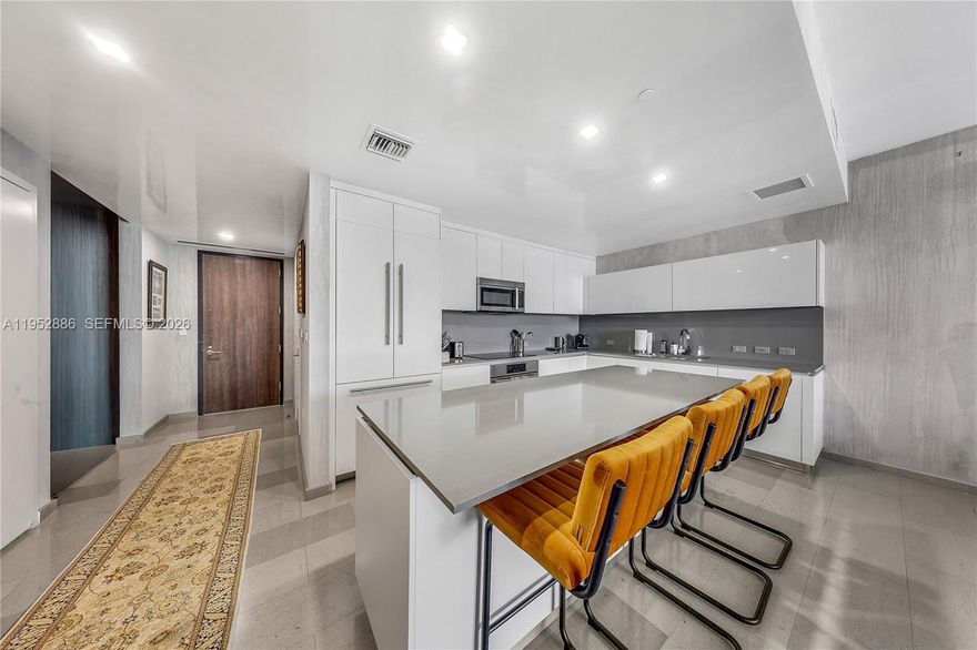 Discover the ultimate urban sanctuary in this coveted 09-line residence at Reach, directly connected to the world-class shopping, dining, and entertainment of Brickell City Centre. This sophisticated 2-bedroom, 2.5-bathroom plus DEN residence spans 1,395 sq. ft. of interior luxury, offering a perfect blend of style and functionality. Floor-to-ceiling glass walls flood the space with natural light, framing breathtaking views of the Miami skyline and Biscayne Bay. The versatile open layout features a dedicated den—ideal for a home office or media room—and a chef-caliber kitchen equipped with Italian Italkraft cabinetry and premium Bosch appliances. Step out onto your expansive terrace to soak in the energy of the city from above.   Residents enjoy exclusive access to a half-acre amenity deck featuring tropical gardens, heated lap and social pools, a state-of-the-art fitness center, and a signature hammam spa. Live effortlessly with concierge service and direct elevator access to Miami’s premier lifestyle destination. This is not just a condo; it's the center of your world. Live where energy, elegance, and ease all come together - only at REACH.