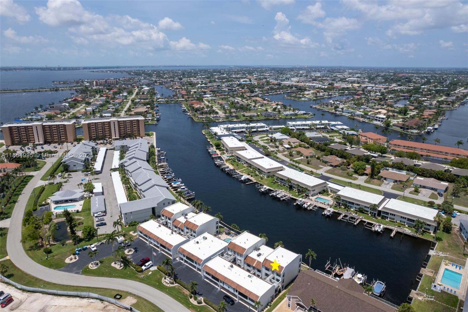 PENTHOUSE with DIRECT GULF ACCESS & STUNNING WATERFRONT VIEWS! Across from the exciting Jaycee Park renovation in SE Cape Coral, this FULLY FURNISHED 2BR/2BA top-floor condo overlooks the 200+ ft Navarro Canal with just one turn to the river & Gulf. Enjoy a private screened balcony/sunroom, vaulted ceilings, impact windows, stone feature wall, spacious kitchen, walk-in closet, and in-unit laundry. Community offers crystal-clear pool, scenic walkways, and optional dockage (assessments paid). Newer A/C, water heater, range, disposal, and re-piped plumbing. Beach Pkwy Promenade location close to SWFL’s best beaches, dining, and shopping. 55+ community, move-in ready—live the Florida waterfront lifestyle!
