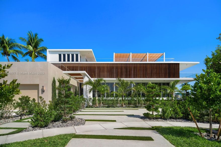 Step Inside With Me! Find statuesque style within a gated community just 12 minutes from Bal Harbour Shops. Water, light, and louvers are balanced throughout this never lived in 8,200 SF home. Offering 11' ceilings in the main salon, custom millwork, oak flooring, a sleek dine-in kitchen by Mia Cucina, and specialty lighting. The upper media lounge leads to a primary suite floating above Biscayne Bay featuring a grand dressing room & spa style bath. Entertain at the epic rooftop deck offering 270° Eastern views, a proper kitchen, and unique trellis. The outdoor living areas are abundant with a second summer kitchen, 70' glass pool, spacious sun deck, 2,000sf dock & 163 FT on the water. A generator, putting green, 2 car garage complete this ultra modern Pinnacle property of Keystone Point.