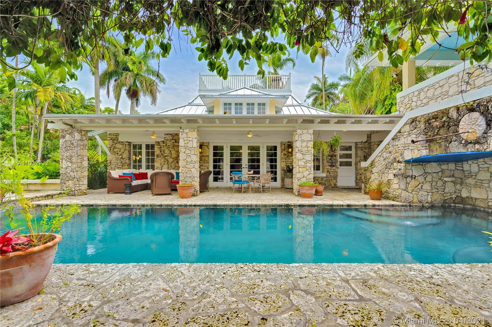 "CORAL BROOK" An architecturally distinctive home of timeless elegance lovingly restored & updated.
Gated entry to a private coral rock paradise. Two fountains feed the brook and whisper "welcome home".
Lushly landscaped Fairchild-style ½ acre garden, covered courtyard patio. French doors lead to the living areas
in the main house. Exotic hardwood floors, spacious chef-style kitchen. 3 ground floor bedrooms & 2 full baths. Upstairs a master suite with exquisite bath, walk-in closets, skylight &Â access rooftop Captain's Walk. Screened porch overlooks a fish pond. Roofed patio & heated saltwater pool with waterfall + jacuzzi. 2-car garage/laundry/cabana bath has a charming guest quarters and balcony above. Live in luxury engulfed in nature and surrounded by history.