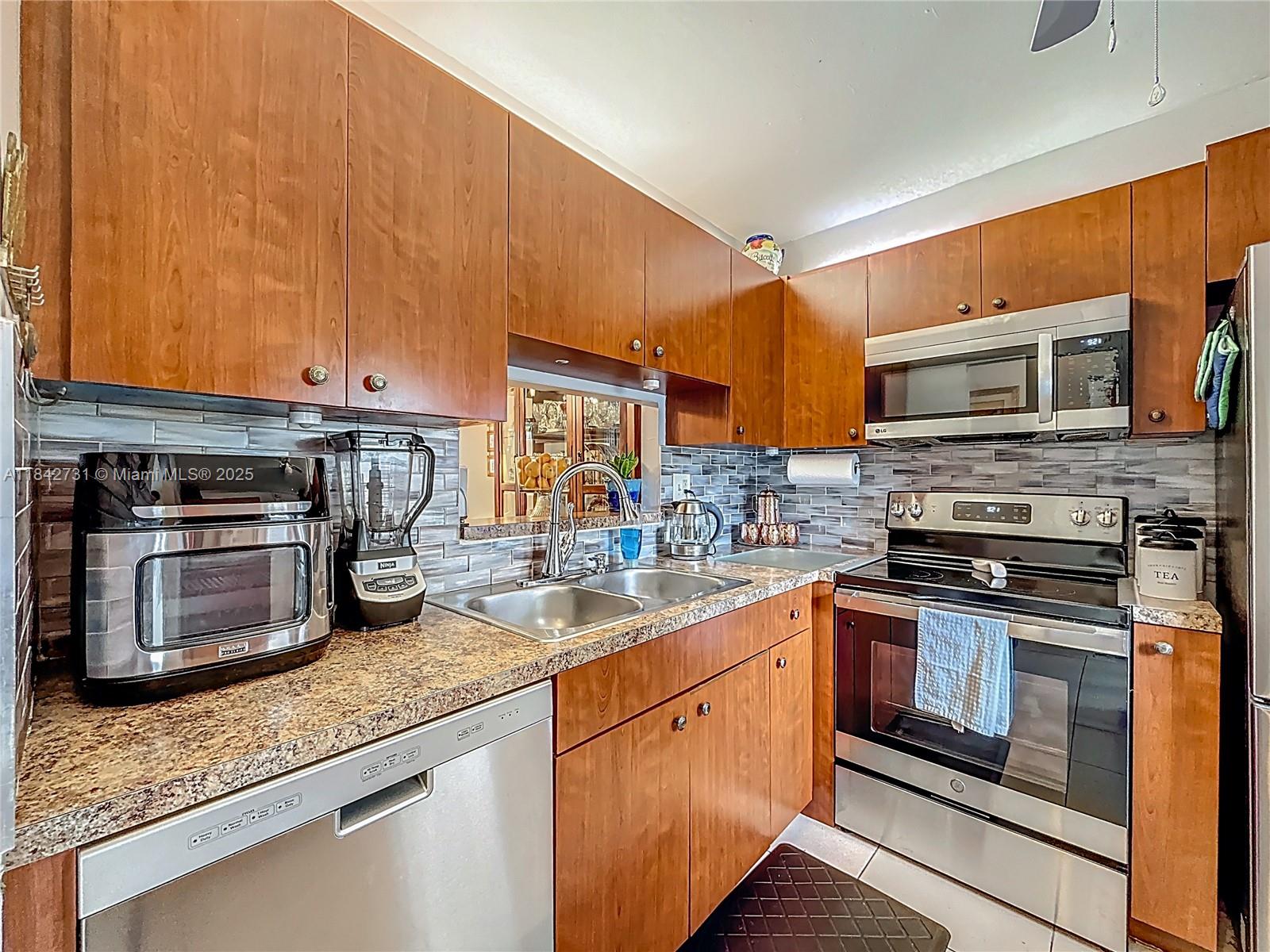 Beautifully updated 2-bed, 2-bath ground-floor unit in the highly sought-after Hawaiian Gardens! This spacious 944 sq ft condo features tile flooring throughout, a renovated kitchen with stainless steel appliances and modern backsplash, and updated bathrooms with granite vanities and glass shower doors. Enjoy an enclosed Florida room with access to a beautifully landscaped green space and your own private gated entry. Assigned parking right in front of the unit. Hawaiian Gardens offers a resort-style pool, clubhouse, shuffleboard, walking trails, lakes, and tropical landscaping. 55+ community.