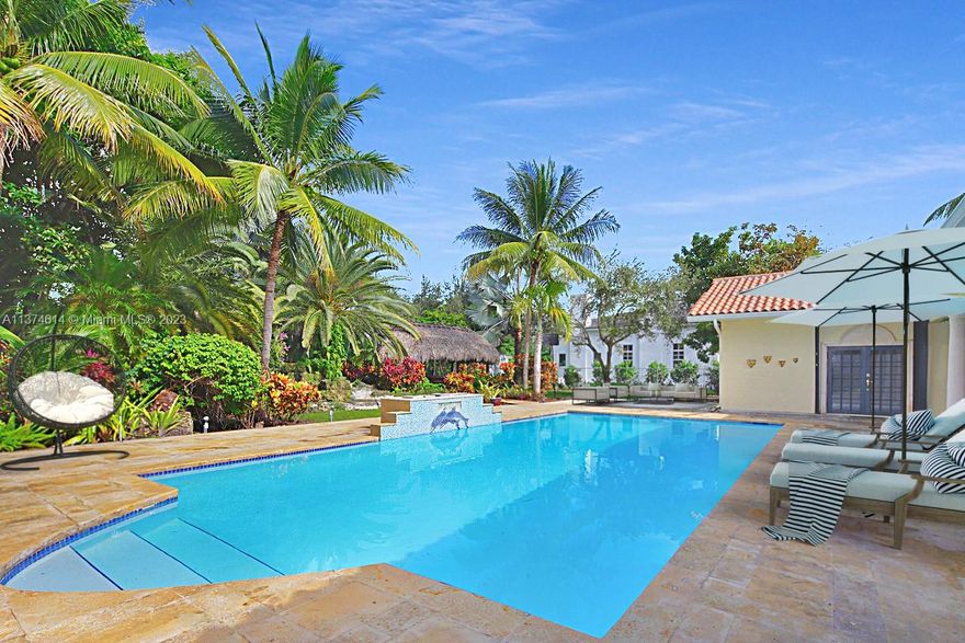 Double-gated , Grande porte-cochere entry to this beautifully renovated acre + home on one of the most idyllic and private streets in Pinecrest. Includes a triple split 5 bedroom plan, large rooms, fireplace, brazilian cherry wood floors throughout and more. Family and formal dining rooms look out onto oversized pool. Outdoor features include a waterfall lagoon/koi pond, chickee hut and a winding path leading to a majestic Banyan tree. Best schools in Pinecrest.