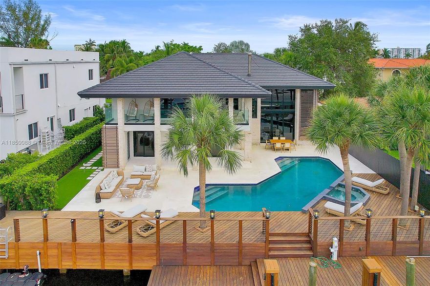 Experience luxury in this stunningly remodeled waterfront pool home in Miami. This furnished professionally designed masterpiece showcases WOW factor two-story windows and living/dining area inviting abundant natural light into your private sanctuary. The pool & entertainment area boast breathtaking views of the putting green, dock, & dual jet ski ramp, perfect for outdoor enthusiasts. Modern gourmet kitchen with an island & wine bar. Primary bedroom with large terrace overlooking the pool, ideal for sunsets. Spacious closet & his-and-hers master baths. Family room & upstairs den for versatile living. Laundry room & two-car garage with circular driveway, 80 feet of waterfront access. Situated in a gated neighborhood. Enjoy nearby beaches, Aventura, & Bal Harbour Shops all just moments away