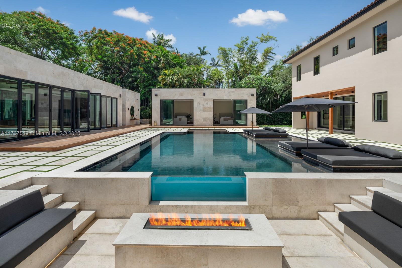 Nestled on a sprawling 40,946 SF lot in North Pinecrest, this resort-inspired estate is designed for ultimate luxury and relaxation. Influenced by the serene elegance of Nizuc Resort, Amangiri’s minimalist sophistication, and Japanese wabi-sabi aesthetics, this modern hacienda, Casa Piedra, seamlessly blends nature and architecture. Set for completion in Spring 2025, the 9,000 SF main residence and 2,000 SF pavilion are united by a stunning Balinese-style pool, the nucleus of the home. With 11,400 SF under air, the estate offers 10 bedrooms, 9 full baths, and 2 powder rooms. A lavish primary suite, chef’s kitchen, grand rotunda, media room, and resort-style amenities create a private oasis perfect for intimate retreats or grand entertaining.