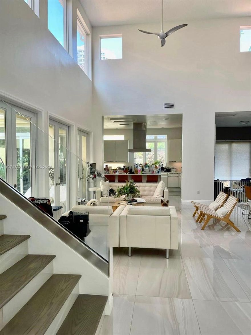 Discover a rare offering on prestigious Island Way—a fully renovated two-story residence where elegance and serenity exist in perfect harmony. Set on a private corner lot beside the community pool, this modern sanctuary blends beauty, location, and lifestyle effortlessly. Wrapped in cascading ivy, the home presents a romantic façade crowned by a new barrel roof, impact windows and doors, and a two-car garage with driveway parking for two additional vehicles.
Beyond the entrance, a private courtyard and heated pool with jets and ambient lighting create an intimate retreat, complemented by a versatile indoor-outdoor cabana room ideal for entertaining, a home office, gym, or lounge. Inside, soaring ceilings, porcelain floors, and airy volumes enhance the seamless indoor-outdoor flow. The open chef’s kitchen features a spacious island, induction cooktop with hood, wine cooler, and paneled Sub-Zero refrigerator, while fully renovated bathrooms add refined comfort. A sleek wooden staircase with glass railings connects both levels, reflecting modern sophistication.
Additional upgrades include a new AC system with Nest thermostat and new water heater for efficiency and peace of mind. Just steps away, enjoy tranquil strolls along the scenic Waterways Walkway, with waterfront views and gentle breezes shaping your daily rhythm. Ideally located, top-rated schools, hospitals, fine dining, and shopping, offering privacy, luxury, and convenience at your doorstep.