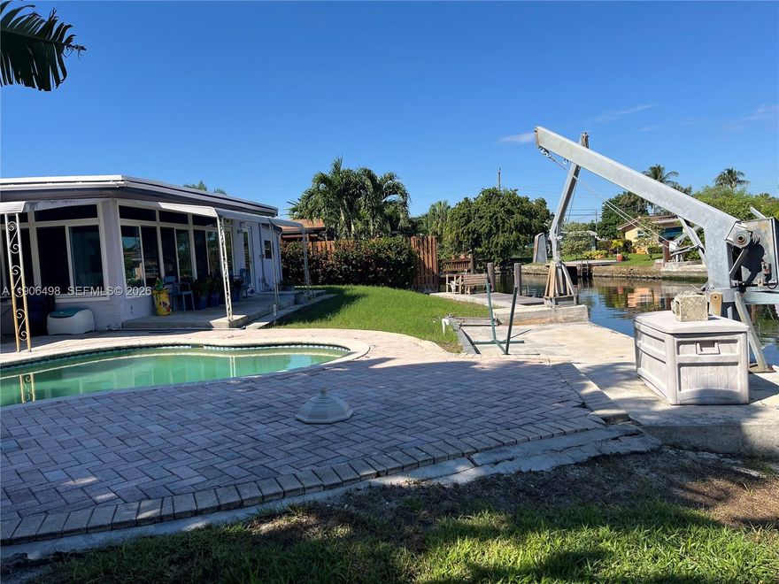 Attention Boaters!!! 100 Ft. Seawall with Ocean Access! 3 bedroom 2 bath spacious home includes a huge open back room off the dining area with full view of the canal plus a Butlers pantry off the kitchen, a laundry room with space for storage and an additional exterior door, possibly for your future cabana bath!. Private Master Bedroom with Bath and Walk-In Closet on one side of living room, additional 2-Spacious Bedrooms with Bath between on the other side. Complete high impact/sound proof windows and doors and covered carport. Good size yard with in-ground pool uniquely shaped to fit perfectly on the side yard! Melaleuca Gardens is a Hidden Gem in Dania Beach. NO HOA! Quiet community where neighbors know each other, minutes from everything including Shopping & Restaurants, Dania Pointe, Airport, Interstate, Beach, and minutes to the Ocean from your boat docked right behind your home. Made with good solid Miami-Dade Pine. Clean and move in ready! Very flexible with showing times!