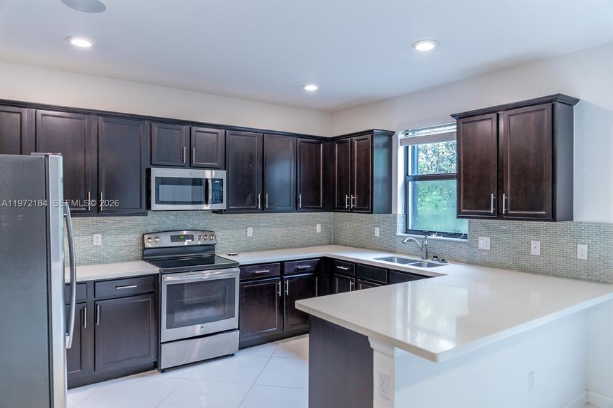 Move-in ready former model in Ashton Parc with interior painted April 2026. Built in 2017, this 3-bedroom, 2.5-bath townhome offers modern construction and a low HOA. Bright open layout features porcelain tile on the main level and updated wood flooring upstairs. The kitchen is designed for everyday living and entertaining with quartz countertops, stainless steel appliances, and an extended snack bar. Custom details include coffered ceilings, feature walls, and built-in surround sound. Accordion shutters provide full storm protection. Step outside to a private extended paver patio, ideal for relaxing or hosting. Located near the community pool with convenient guest parking. Ideally situated near Boca Raton, beaches, shopping, dining, and major highways. A well-positioned opportunity in one of Coconut Creek’s most desirable communities.