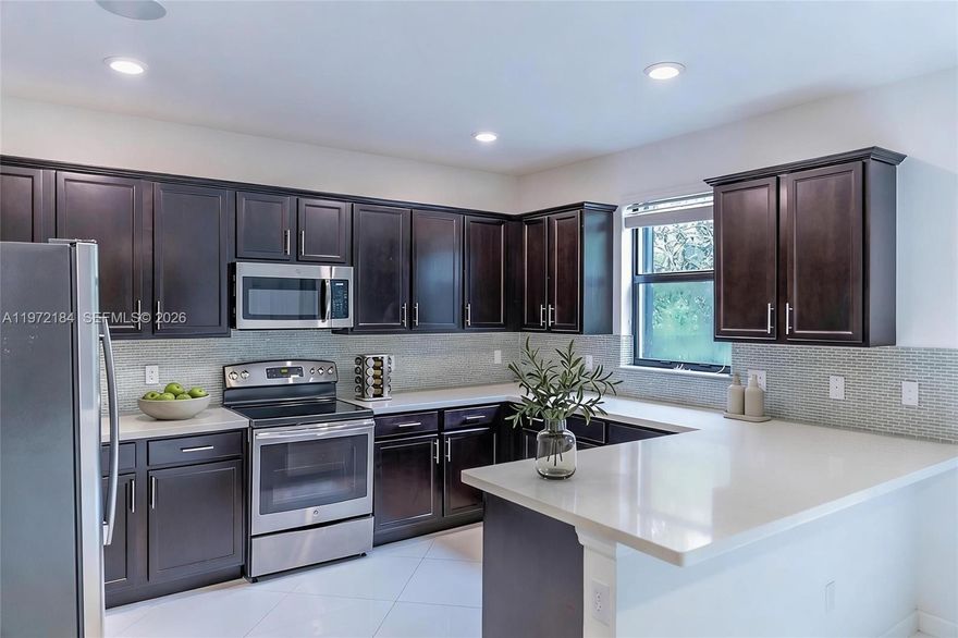 Move-in ready former model in Ashton Parc with interior painted April 2026. Built in 2017, this 3-bedroom, 2.5-bath townhome offers modern construction and a low HOA. Bright open layout features porcelain tile on the main level and updated wood flooring upstairs. The kitchen is designed for everyday living and entertaining with quartz countertops, stainless steel appliances, and an extended snack bar. Custom details include coffered ceilings, feature walls, and built-in surround sound. Accordion shutters provide full storm protection. Step outside to a private extended paver patio, ideal for relaxing or hosting. Located near the community pool with convenient guest parking. Ideally situated near Boca Raton, beaches, shopping, dining, and major highways. A well-positioned opportunity in one of Coconut Creek’s most desirable communities.